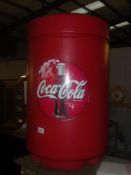 A large plastic Coca Cola waste bin