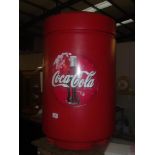 A large plastic Coca Cola waste bin