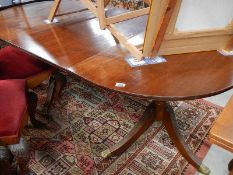 A mahogany twin pedestal table with one extra leaf.