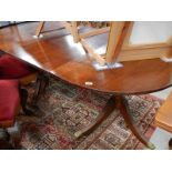 A mahogany twin pedestal table with one extra leaf.