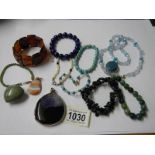 A mixed lot of stone pendant and bracelets, various coloured stones.