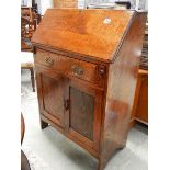 An oak paneled desk with one drawer and side doors.