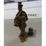 A miniature silver tramp figure.