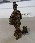 A miniature silver tramp figure.