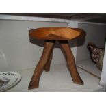 A small 3 legged stool with carved face/head of a retriever on seat
