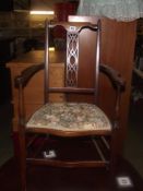 An Edwardian inlaid carver arm chair with floral tapestry seat