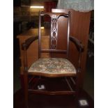 An Edwardian inlaid carver arm chair with floral tapestry seat