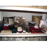 A shelf of empty jewellery boxes, small cushions, bow tie and cufflinks, watch,