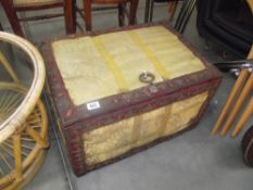 An upholstered chest with metal dragon loop handle