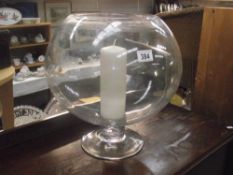 A large glass fish bowl candle holder