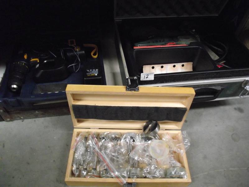 A Bosch cast with sander, box of wood drill bits, boxed drill with battery and empty case.