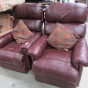 A pair of burgundy reclining arm chairs.