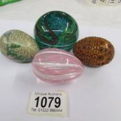 A Nailsea glass egg, a carved egg (a/f), a cloisonne egg and a glass paperweight.