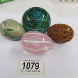 A Nailsea glass egg, a carved egg (a/f), a cloisonne egg and a glass paperweight.