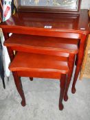 A nest of 3 mahogany tables.