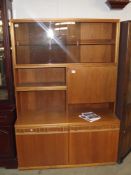 A 1970s teak sideboard with smoke glass sliding doors