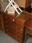 A solid pine bedroom chest of drawers with glass top