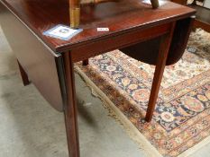 A mahogany drop leaf dining table.