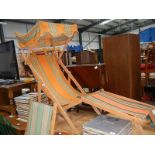 A vintage deck chair with sun cover and one other.