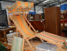 A vintage deck chair with sun cover and one other.