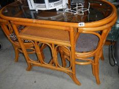 An oval wicker table and 2 chairs.