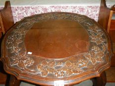 A carved top mahogany table.