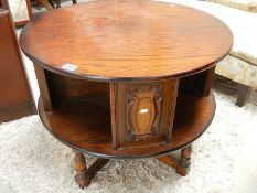 A circular oak coffee table with carved panels.