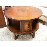 A circular oak coffee table with carved panels.