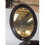 An oval bevel edge mirror in frame