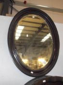 An oval bevel edge mirror in frame