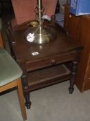 A hall side table with single drawer and a woven wicker undershelf