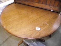 A round pedestal satined oak table