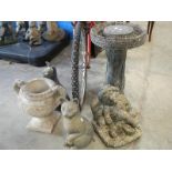 A concrete bird bath, urn and 2 plastic cats.