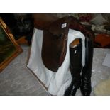 An old leather saddle and pair of riding boots.