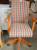 A pine based swivel arm chair.