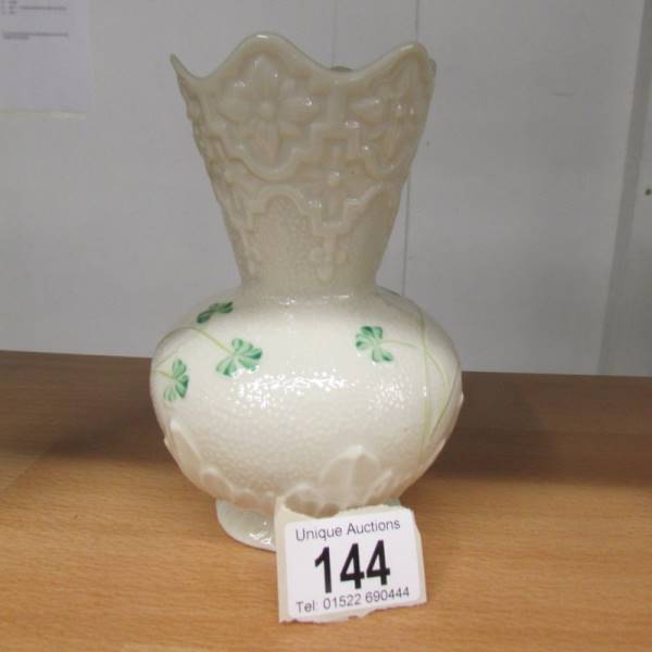 A Belleek vase decorated with shamrocks. 15 cm tall.