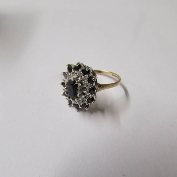 A diamond and sapphire cluster in an oval shaped ring in 9ct gold, dated Birmingham 1987, - Image 2 of 2
