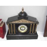 A black slate mantel clock with 6 brass columns