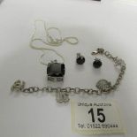 A silver and onyx necklace and earrings together with a silver charm bracelet.