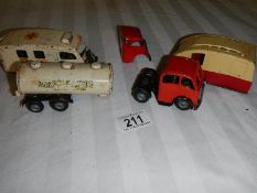 A Triang Minic tinplate clockwork ambulance, a milk tanker and a caravan.