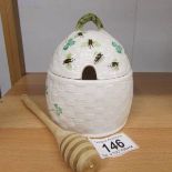 A Belleek honey pot decorated with shamrocks and bees.