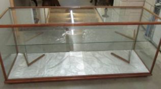 A glass shop cabinet. 61" long x 19.