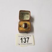An art deco gold ring set large red stone.