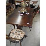 A dark oak draw leaf table and 4 Ercol chairs.