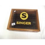 A table top display cabinet with Singer advertising