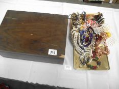 A tin of costume jewellery and a wooden box and contents