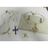 A necklace with matching earrings, a cross on chain and a pearl necklace.