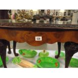 A dark wood nest of 3 tables with glass tops.
