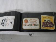 2 albums of whisky labels and mid 20th century beer mats.