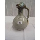An unusual stoneware jug with handle. A birds head forms the lid and spout.